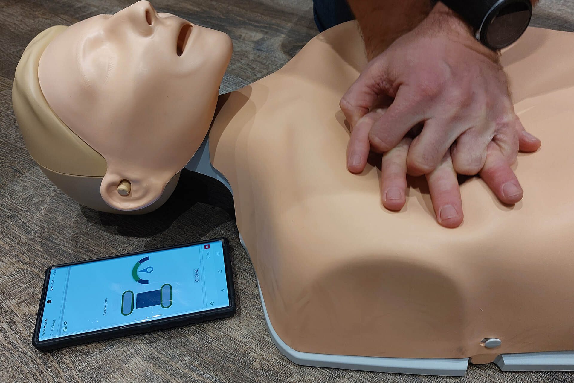 A First Aid Instructor showing course attendees how to perform CPR during a Basic Life Support course.